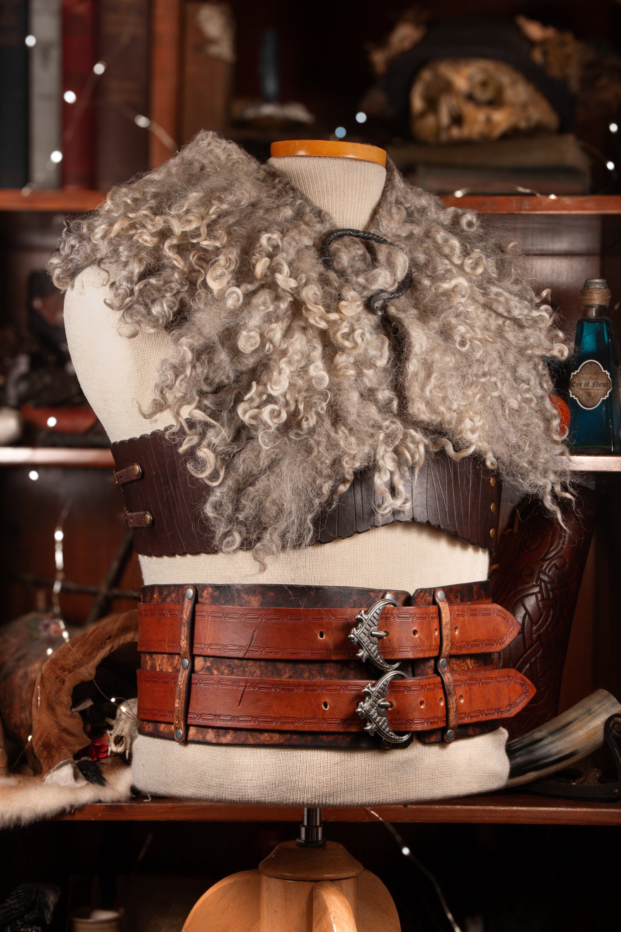 A two-tiered warrior belt with metal buckles and a raven design on the back, displayed on a mannequin.
