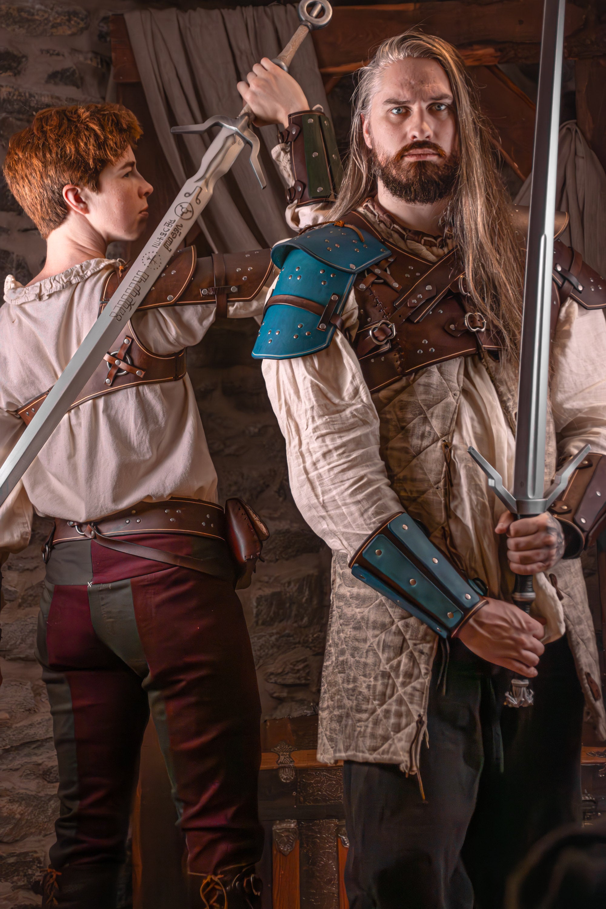 Two characters in medieval or fantasy attire holding swords in a stone-walled room.